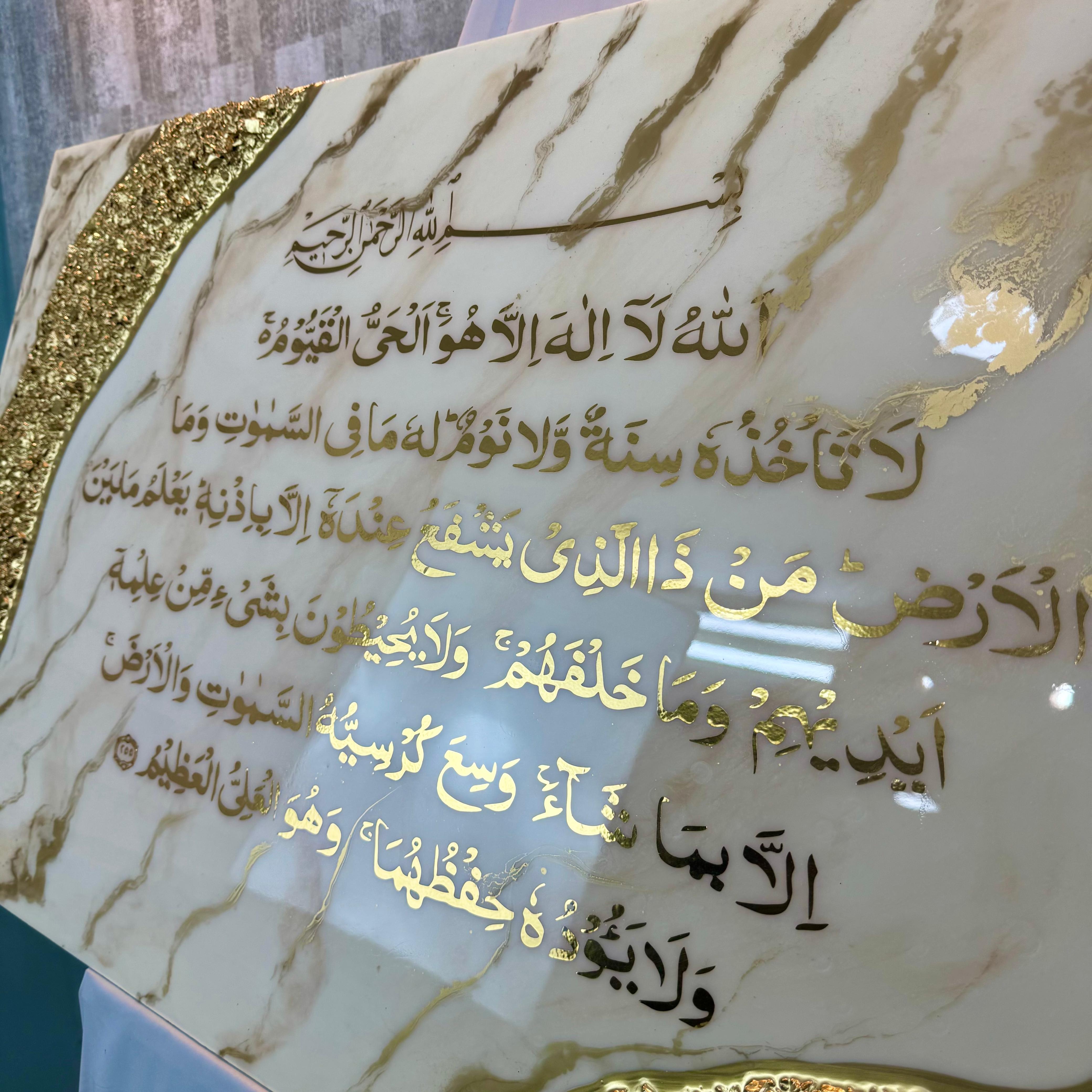 Un détail qui révèle tout l’éclat de l’œuvre : Ayat Al-Kursi dorée, effet marbré délicat et finition résine brillante pour un rendu lumineux, profond et raffiné.